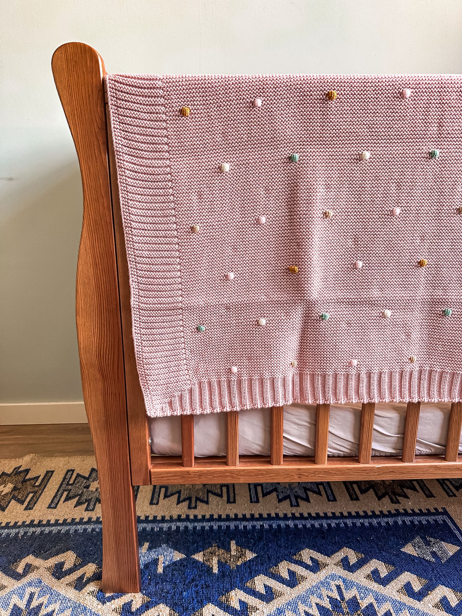 zachte roze babydeken met gekleurde puntjes erop